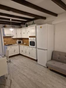 a kitchen with white cabinets and a white refrigerator at Mamie Krema in Boresse-et-Martron
