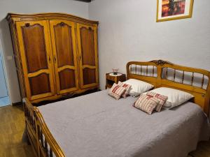 a bedroom with a wooden bed with two pillows at Mamie Krema in Boresse-et-Martron