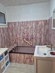 a bathroom with a bath tub and a sink at Mamie Krema in Boresse-et-Martron