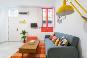 a living room with a blue couch and a table at Duplex Seville-Historic Center in Seville