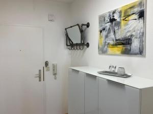 a bathroom with white cabinets and a painting on the wall at Dmon-Home in Tettnang +36 photos