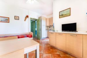 a living room with a television and a kitchen at I girasoli in Villasimius