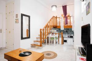 a living room with a staircase and a table at Duplex Seville-Historic Center in Seville