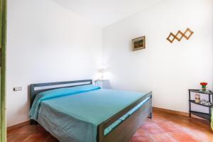 a bedroom with a bed in a white room at I girasoli in Villasimius +16 photos
