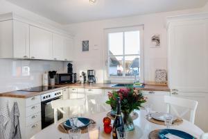 a kitchen with white cabinets and a table and chairs at Ferienhaus Mühlenperle in Güstow