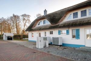 a white house with a thatched roof at Ferienhaus Mühlenperle in Güstow