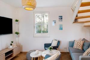 a living room with a couch and a tv at Ferienhaus Mühlenperle in Güstow