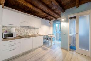 a kitchen with white cabinets and a table at Prima Del Cielo - Appartamento Lago in Esino Lario