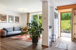 a living room with a couch and a plant at Krottenhill 2 ¼ in Ingenried