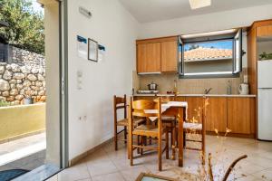 a kitchen with a table and chairs and a refrigerator at Alkionides Apartment 3 in Agios Nikitas +16 photos