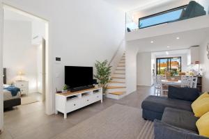 a living room with a couch and a tv and a staircase at Casa do Sol and Golf - Vilamoura in Vilamoura