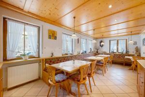 a restaurant with wooden ceilings and tables and chairs at Gästehaus Herrmann in Bad Rippoldsau-Schapbach