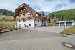 a large white house with a large driveway at Gästehaus Herrmann in Bad Rippoldsau-Schapbach