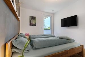 a bedroom with a bed and a flat screen tv at Kölsch-Marie in Durbach