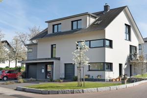 a white house with a tree in the front yard at Kölsch-Marie in Durbach