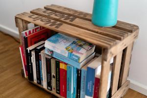 a book shelf filled with books and a blue vase at Kölsch-Marie in Durbach