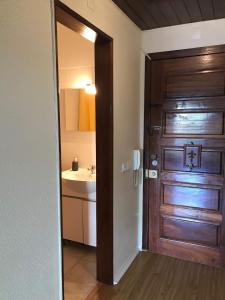 a bathroom with a wooden door and a sink at Estoril Sea You in Estoril