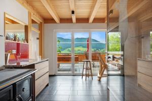 a kitchen with a view of a table and chairs at Schonzeit Chalet in Bernau im Schwarzwald