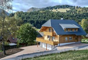 a wooden house with a blue roof at Schonzeit Chalet in Bernau im Schwarzwald