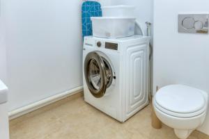 a white washing machine in a bathroom with a toilet at Appartement Port Lin proche Océan in Le Croisic
