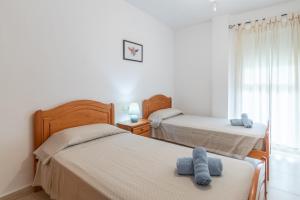 two beds in a room with two blue towels on them at Edificio Menorca in Balcon del Mar +17 photos