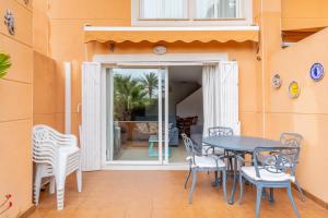 a patio with a table and chairs in front of a door at Edificio Menorca in Balcon del Mar