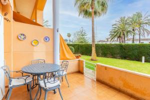 a balcony with a table and chairs and a palm tree at Edificio Menorca in Balcon del Mar