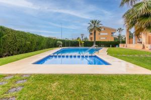 a swimming pool in a yard with palm trees at Edificio Menorca in Balcon del Mar