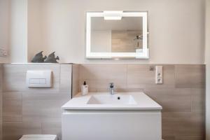 a bathroom with a white sink and a mirror at Kleines Glück in Delmenhorst +16 photos