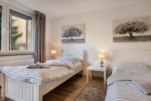 two beds in a room with two windows at Kleines Glück in Delmenhorst