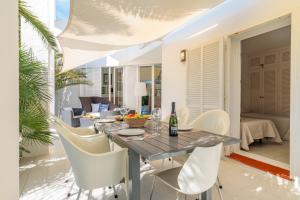 a dining room with a table and white chairs at Casa Arola in Sant Josep de sa Talaia