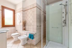 a bathroom with a toilet and a glass shower at Appartamento Libio Porto Torres in Porto Torres +15 photos
