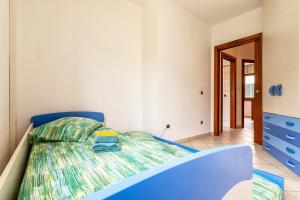 a bedroom with a blue bed in a room at Appartamento Libio Porto Torres in Porto Torres
