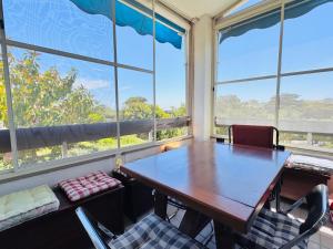 a table and chairs in a room with large windows at Casa Greis in Stintino