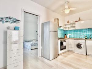 a kitchen with a refrigerator and a washer and dryer at Casa Greis in Stintino +10 photos