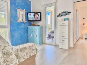 a living room with a blue wall and a dresser at Casa Greis in Stintino