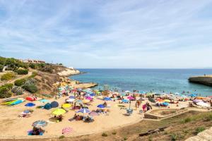a crowd of people on a beach with umbrellas at Appartamento Libio Porto Torres in Porto Torres