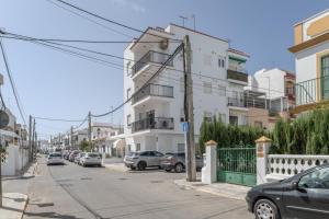 a street with cars parked in front of buildings at Apartamento Playa Regla in Chipiona