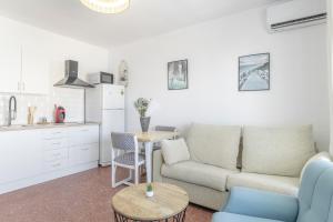 a living room with a couch and a table at Apartamento Playa Regla in Chipiona +16 photos