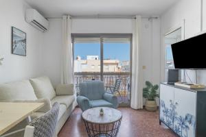 a living room with a couch and a tv at Apartamento Playa Regla in Chipiona
