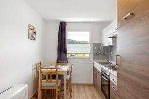 a kitchen with a table and chairs and a window at Ferienhaus Grobbel in Eslohe