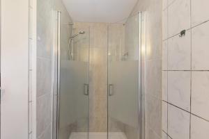 a shower with a glass door in a bathroom at Ferienhaus Grobbel in Eslohe +16 photos