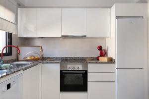 a white kitchen with white cabinets and a stove at Apartamento La Estrella I in Playa Honda