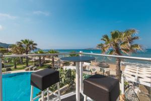 a balcony with a view of a pool and the ocean at Mirage Arillas Maisonette B in Arillas