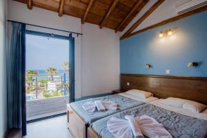 a bedroom with a bed and a large window at Mirage Arillas Maisonette B in Arillas