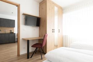 a bedroom with a desk and a bed and a tv at Kleon 3 in Rifiano