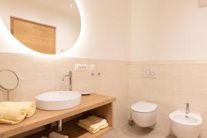 a bathroom with a sink and a toilet and a mirror at Kleon 3 in Rifiano +27 photos