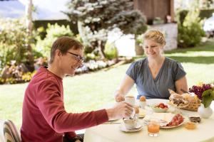 a man and woman sitting at a table eating food at Kleon 3 in Rifiano