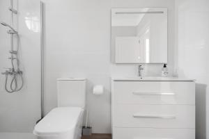 a white bathroom with a toilet and a sink at Casa Alsa Beach in Icod de los Vinos +20 photos