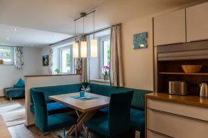 a dining room with a green couch and a table at Haus Alpenheim Apartment 2 in Tux